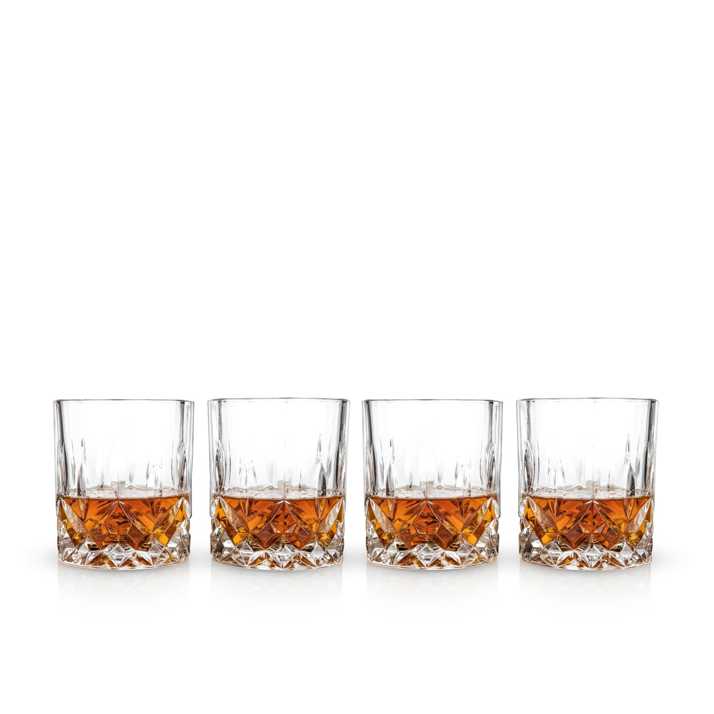 Four glasses of whiskey lined up on a white background