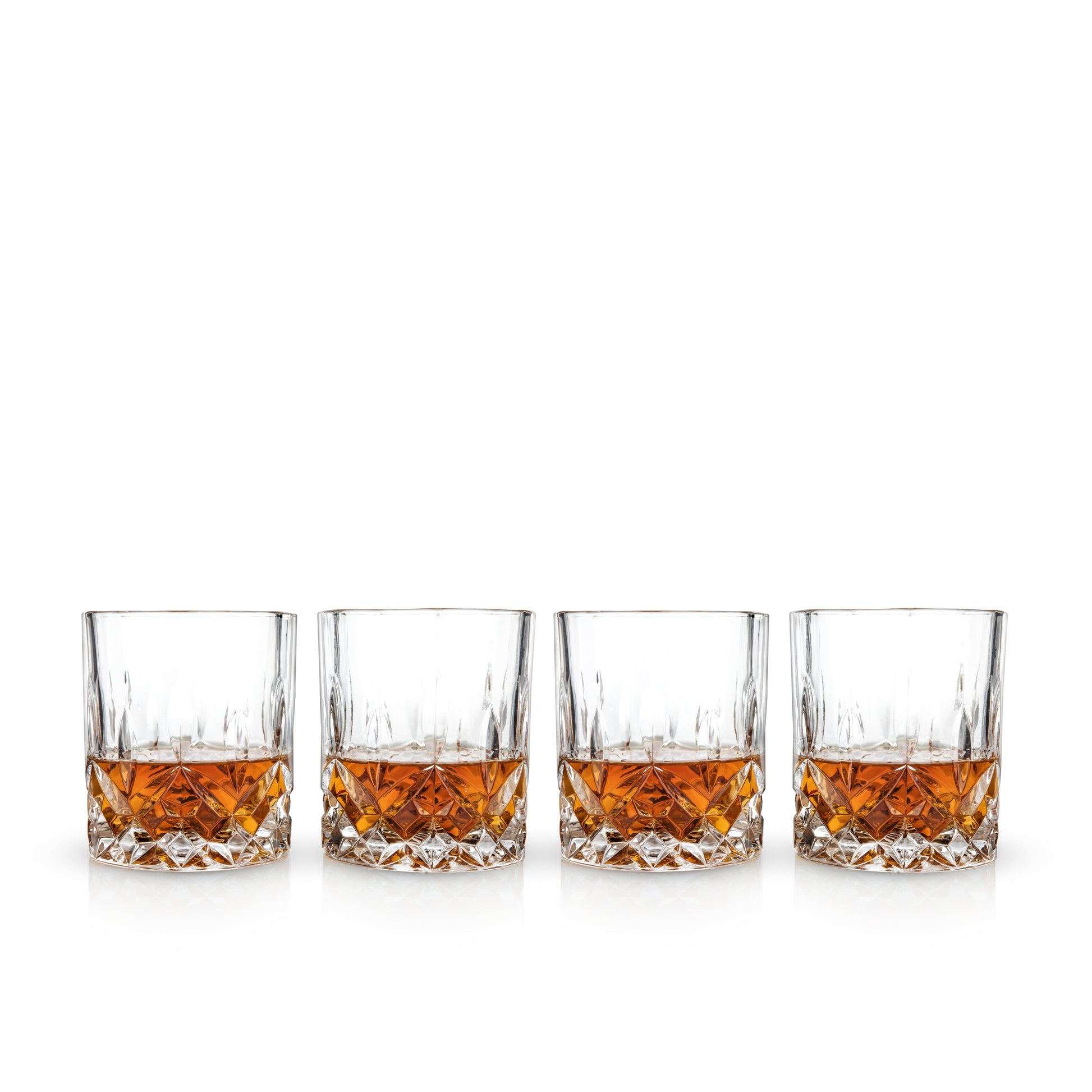 Four glasses of whiskey lined up on a white background